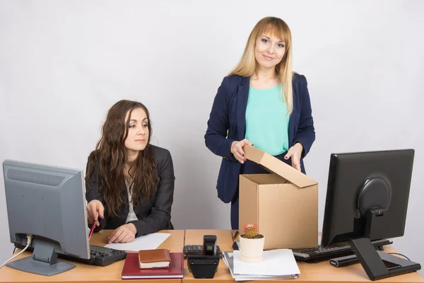 New employee in the office happily arranges things, next to a colleague — Stock Photo, Image