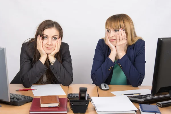 Twee kantoormedewerkers moe gemarteld zittend achter een bureau — Stockfoto