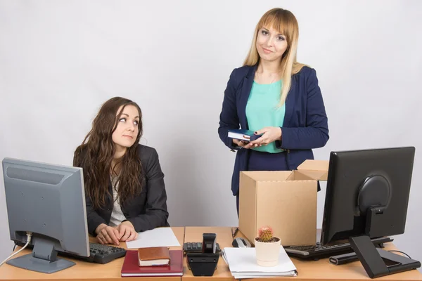 Girl in office standing with a smile in front of a box about colleagues — Stock Photo, Image