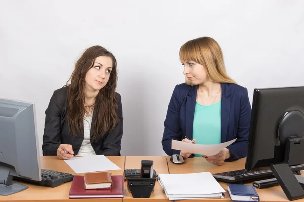 Twee kantoormedewerker zittend op een bureau en een vijandige blik op elkaar — Stockfoto
