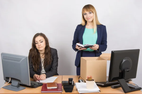 Un employé du bureau sort volontiers les choses de la boîte à côté d'un collègue — Photo