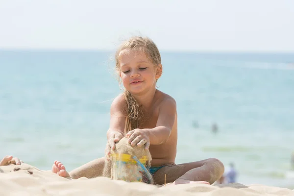 Красивые девушки четыре года играют в песок с ребенком на берегу моря ведро — стоковое фото