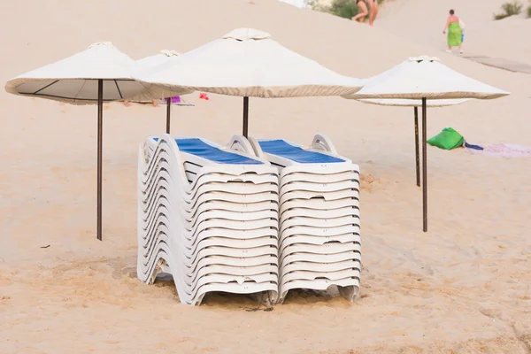 Şemsiye altında plaj sandalyelerinde yığınlar halinde toplanan — Stok fotoğraf