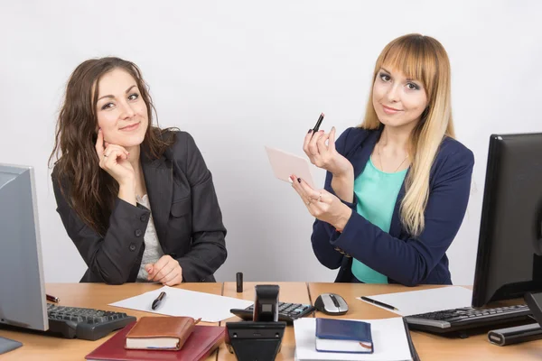 Office employee watches as a colleague is going to make up lips at the desk — Stock Photo, Image