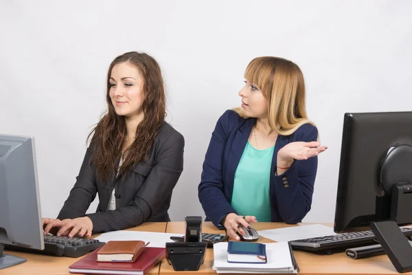 Kontorsarbetare med indignation tittar på en ganska kollega sitter bredvid en dator — Stockfoto