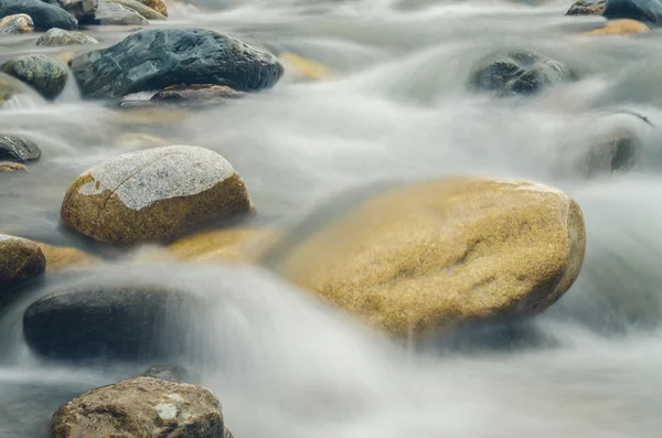 Pedra está no rio da montanha, borrada por uma velocidade lenta do obturador — Fotografia de Stock