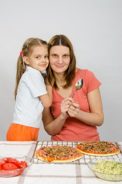 Kızı annesine altı yıl kucaklayan, bir pizza hazırlanıyor