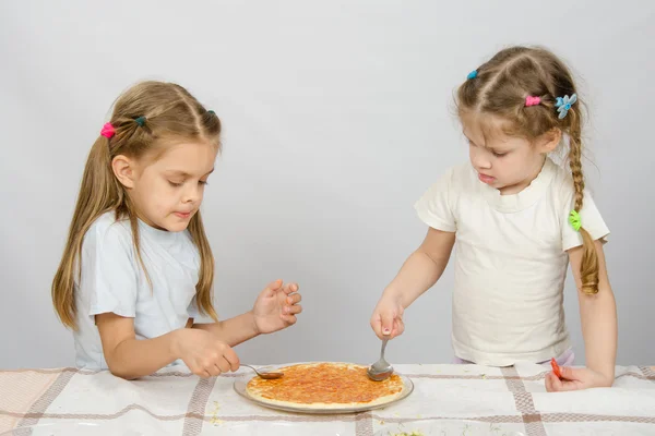 Two little sisters concentrated smear sauce based pizza — Stock Photo, Image