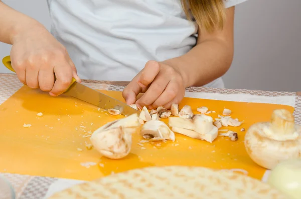 Крупный план детских рук, стрижка ножевых грибов на доске — стоковое фото