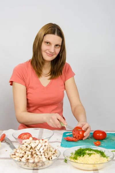 Gadis di meja dapur memotong tomat. — Stok Foto