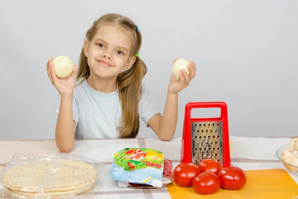 Sex år gammal flicka vid köksbordet har roligt håller grönsaker — Stockfoto