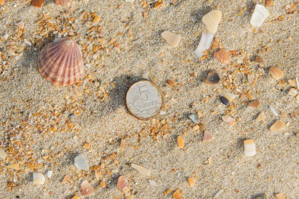 Rusty nickels lying on the sand on a sea beach — Stock Photo, Image