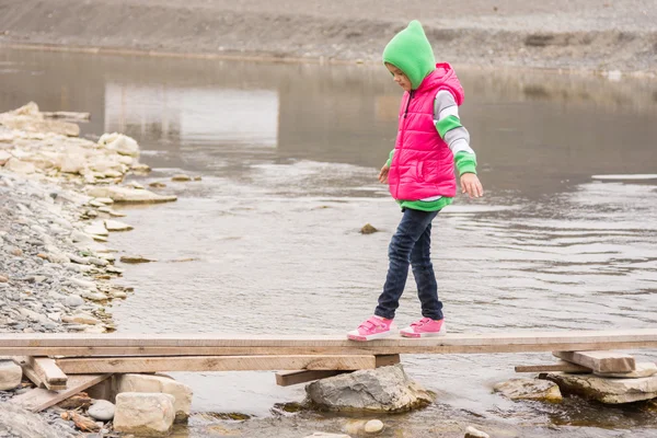 La bambina si è mossa delicatamente attraverso il torrente sulla scacchiera — Foto Stock