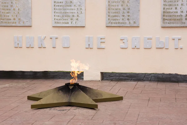 Vityazevo, Rússia - 14 de março de 2016: A chama eterna e as palavras "Ninguém se esquece", close-up, em um monumento em honra dos aldeões mortos Vityazevo na Grande Guerra Patriótica 1941-1945 — Fotografia de Stock