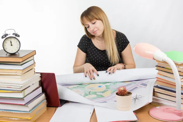 Ragazza studente di design seduto a una scrivania ed è stanco distribuisce un grande disegno — Foto Stock