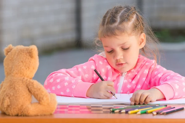 Het meisje met enthousiasme tekent u met kleurpotloden in het album — Stockfoto