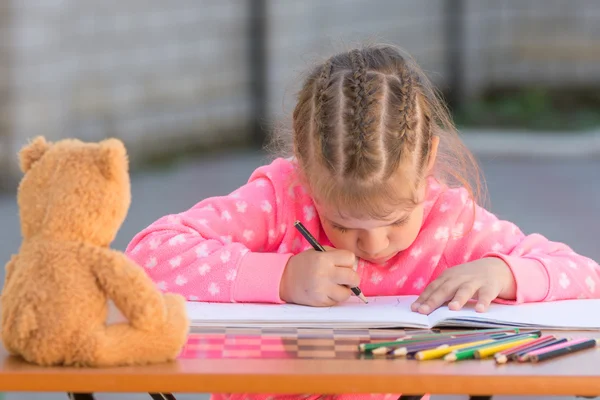 Offended girl draws a hunched figure in the yard — Stock Photo, Image