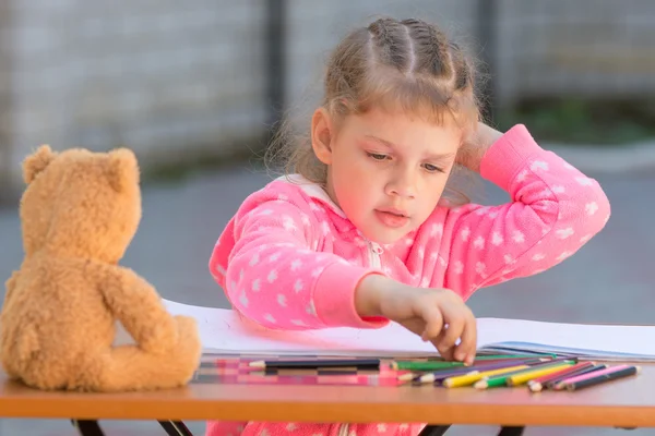 Menina escolhe levado lápis de desenho com a cor desejada — Fotografia de Stock