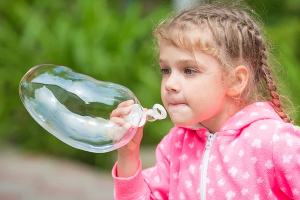 Five-year girl inflates a large soap bubble — Stock Photo, Image