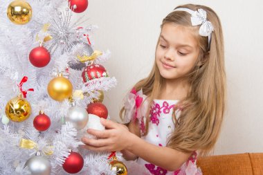 Yedi yıllık kız güzel bir elbise içinde Noel oyuncaklar davranır