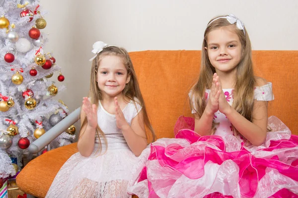 Dos chicas en hermosos vestidos adivinando regalos para el nuevo año — Foto de Stock