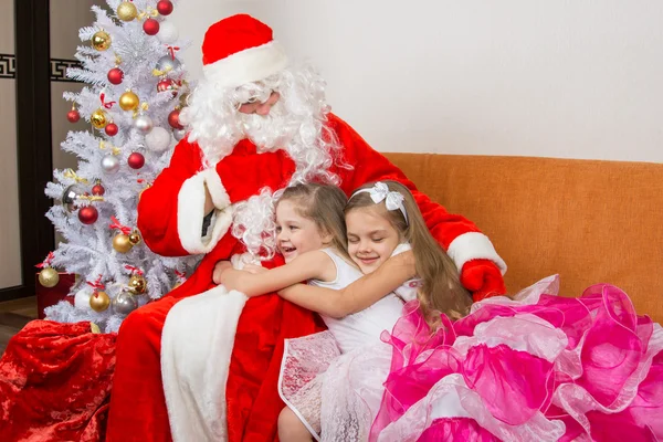 Dos chicas en hermosos vestidos abrazan a Santa Claus — Foto de Stock