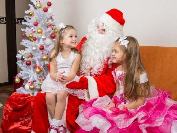 Liten flicka sitter i knät på jultomten och berättar dikt — Stockfoto