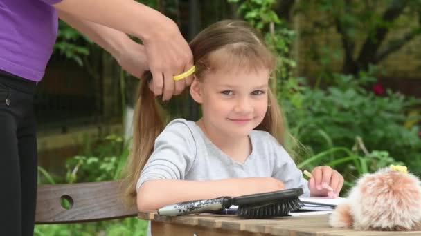 Fille regarde dans l'image est ma mère tresses dans une queue de cheval ses cheveux longs — Video