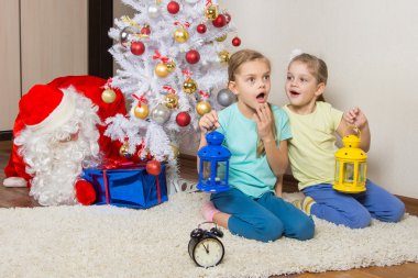 El feneri hediye yılbaşı gecesi ve Noel Baba rüya ile iki kız hediyeleri Noel ağacının altına koymak