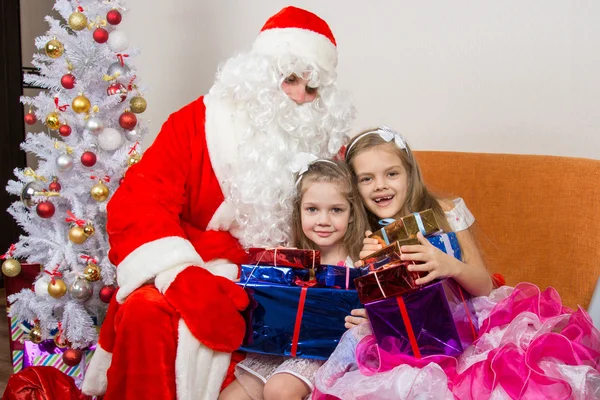 Санта Клаус дарил подарки детям и обнимал — стоковое фото