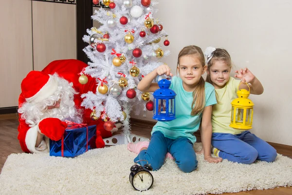 Due ragazze con le torce elettriche in attesa di Babbo Natale all'albero di Natale a Capodanno — Foto Stock