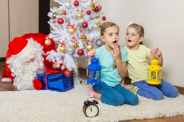 Due ragazze con torce che sognano regali durante la notte di Capodanno, e Babbo Natale ha messo i regali sotto l'albero di Natale — Foto Stock