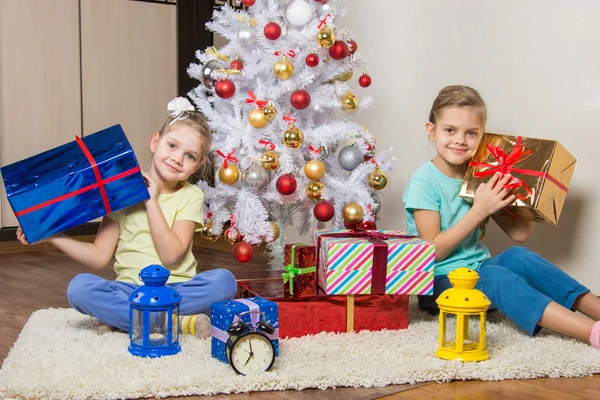 Två små flickor med jul presenterar tidigt på morgonen sitter vid granen — Stockfoto