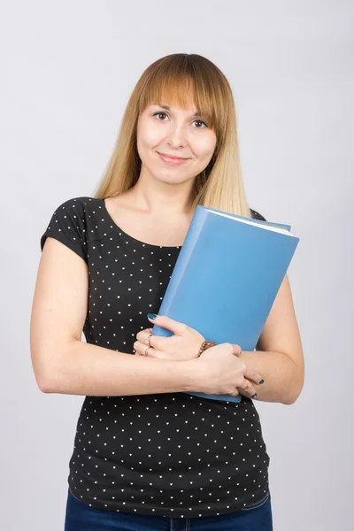 La fille est avec un sourire et tient un dossier avec des documents à sa poitrine — Photo