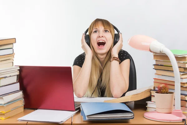 Un estudiante grita de fatiga mientras escucha música en los auriculares —  Fotos de Stock