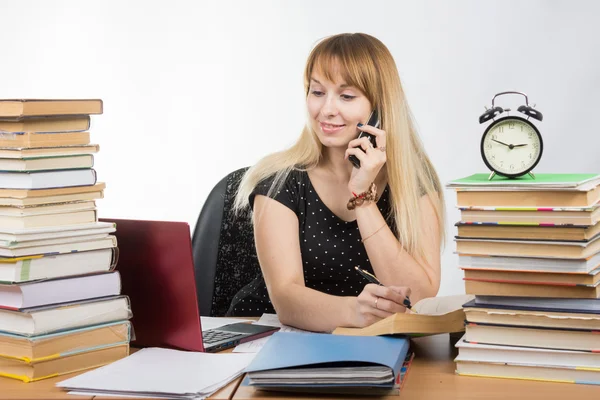 En student förbereder sig för tentor och prata i telefon — Stockfoto