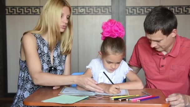 I genitori mostrano a un bambino che ha fatto degli errori facendo i compiti. — Video Stock