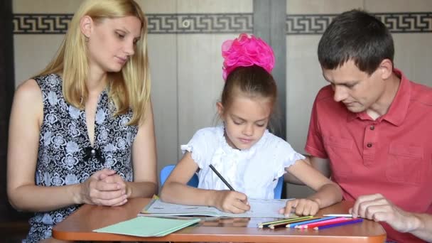 Mamá y papá elogiaron a su hija con su hijo de primer grado haciendo la tarea — Vídeo de stock