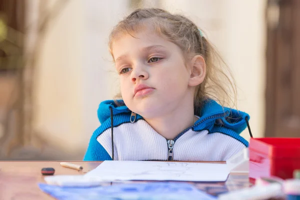 Fille frustrée assise à une table dans la cour et regarde triste nulle part — Photo
