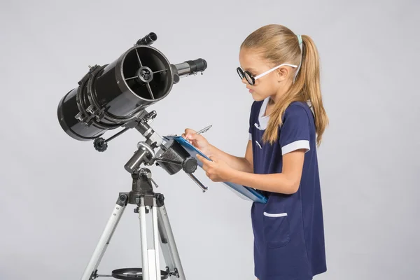 Ung tjej med glasögon skriver astronomen observationer — Stockfoto