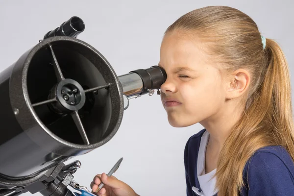 El joven astrónomo mira a través del ocular del telescopio y registra los resultados — Foto de Stock