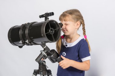 Girl amateur astronomer sets up a telescope for observing the starry sky clipart