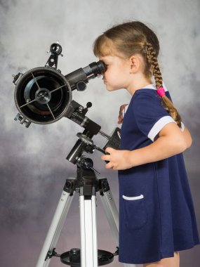 Girl amateur astronomers looking into the telescope eyepiece clipart