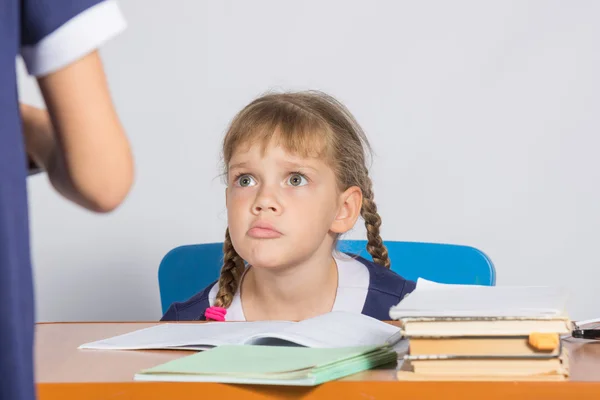 Schülerin, die am Schreibtisch sitzt, blickt ein anderes Mädchen wütend an — Stockfoto