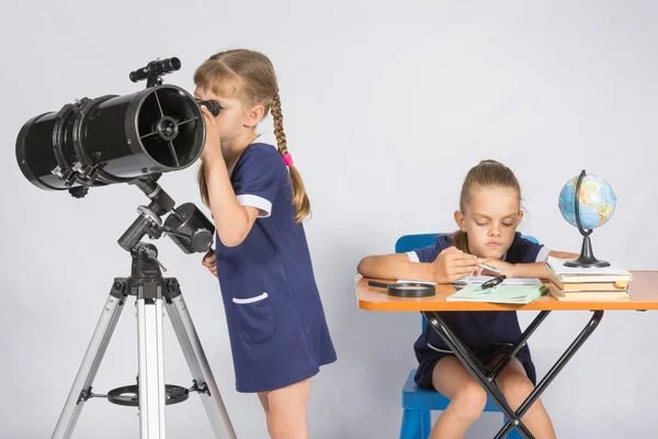 Mädchen beobachtet die Himmelskörper im Teleskop, das andere Mädchen wartet auf die Ergebnisse der Beobachtungen — Stockfoto