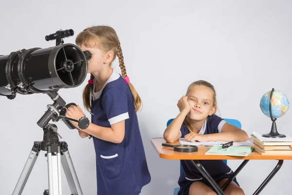 Дівчина дивиться через телескоп, інша дівчина чекає сумних результатів — стокове фото