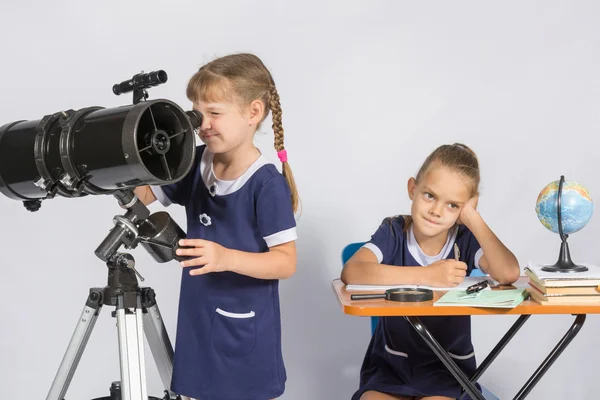 Astronom dívka vypadá prostřednictvím okuláru dalekohledu, druhá holka si čekání na výsledky pozorování — Stock fotografie