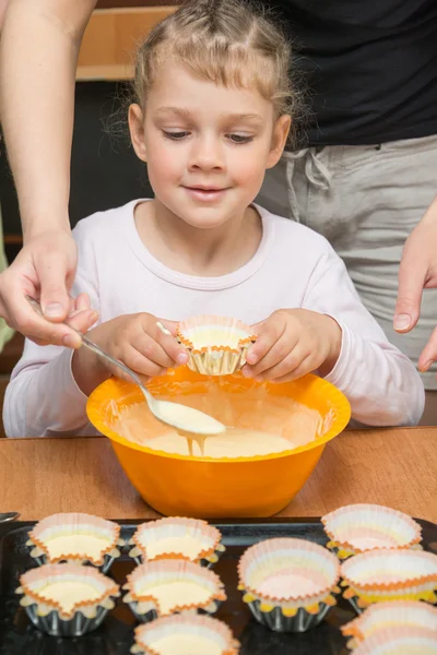 Dotter håller formen för kakan, medan min mamma drar degen ur skålen — Stockfoto