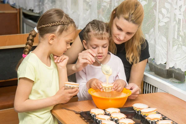 Mamma lär två döttrar att laga påsk cupcakes — Stockfoto