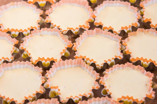 Viele rohe Kuchen in Dosen, fertig zum Braten — Stockfoto